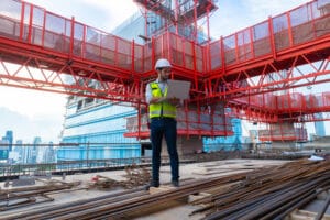 ingegnere che progetta un grande progetto e ispeziona il cantiere per verificare la conformità alle specifiche.